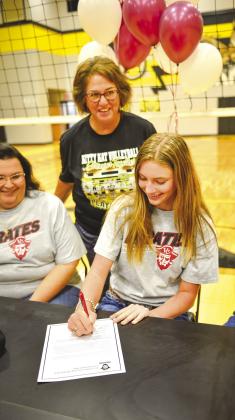 Senior Emie Bolting signs her letter of intent with mom Lorretta Bolting and Coach Irma Gomez looking on proudly.