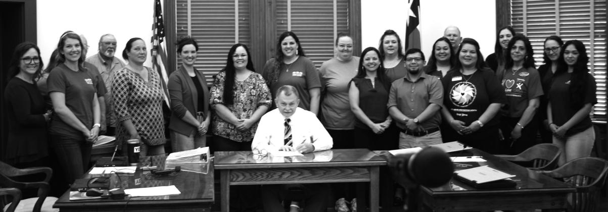Judge Fowler signs a proclamation passed by the DeWitt County Commissioner’s Court on Monday. The court declared April to be Child Abuse Awareness and Prevention Month. Representatives from Norma’s House, the DeWitt County Child Welfare Board, CASA, Belong and the Department of Family Services joined the judge and commissioners at the signing.