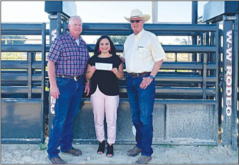 President Greg Gossett, right, and Secretary Anthony Netardus of the Cuero Livestock Show Inc. are shown receiving a check for $10,000 from Samantha Bayfus, center, of the Cuero Development Corporation, for the completion of their Community Services Program. This grant partially paid to purchase new chutes at the Harvey and Jane Mueller Rodeo Arena.