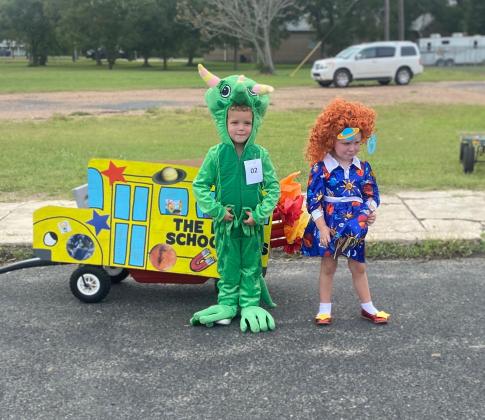 Most Creative Float winners Case Franke and Broghan Owen pose for a photo with their Magic School Bus before the 40th Annual Children’s Parade on Saturday, Oct. 17