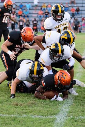 A host of wildcats tackle a Yeguas offensive player.