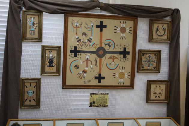 Over 30 Navajo sandpaintings are within the Native American exhibit at The Cuero Heritage Museum. The figures in the back ground of the sand paintings are symbolic representations of a story in Navajo mythology. 