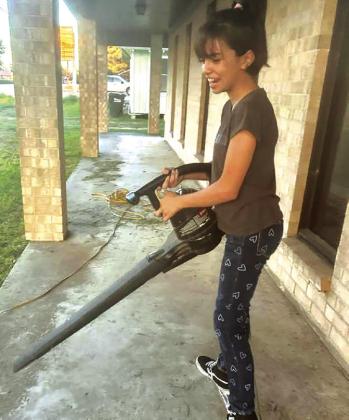 Emma Villanueva cleans up Seifert Center with a leaf blower. CONTRIBUTED PHOTO