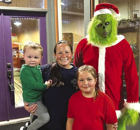 Cullen, Courtney, and Cinley Kulik pose with The Grinch.