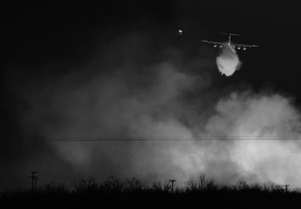 A Texas A&amp;M Forest Service plane drops water on a wall of flames that reaches into the sky as the Smokehouse Creek fire reignited on March 3 near Miami.