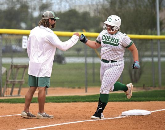 Camdyn Lange celebrates her home run with Coach Miller as she rounds third base.