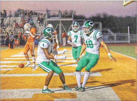 #4 Day’ton Varela, #7 Brayden Hernandez and quarterback Mason Notaro, #18, celebrate one of their seven touchdowns, while a Beeville defender looks dejected in the background.