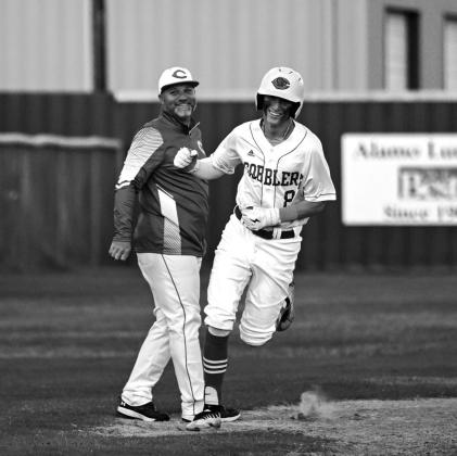 Kyle Nagel celebrates his home run with Coach Bonewald as he rounds third base.